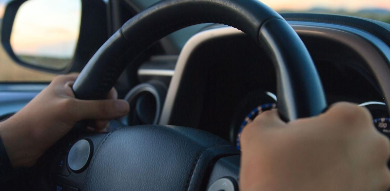 Man holds a steering wheel